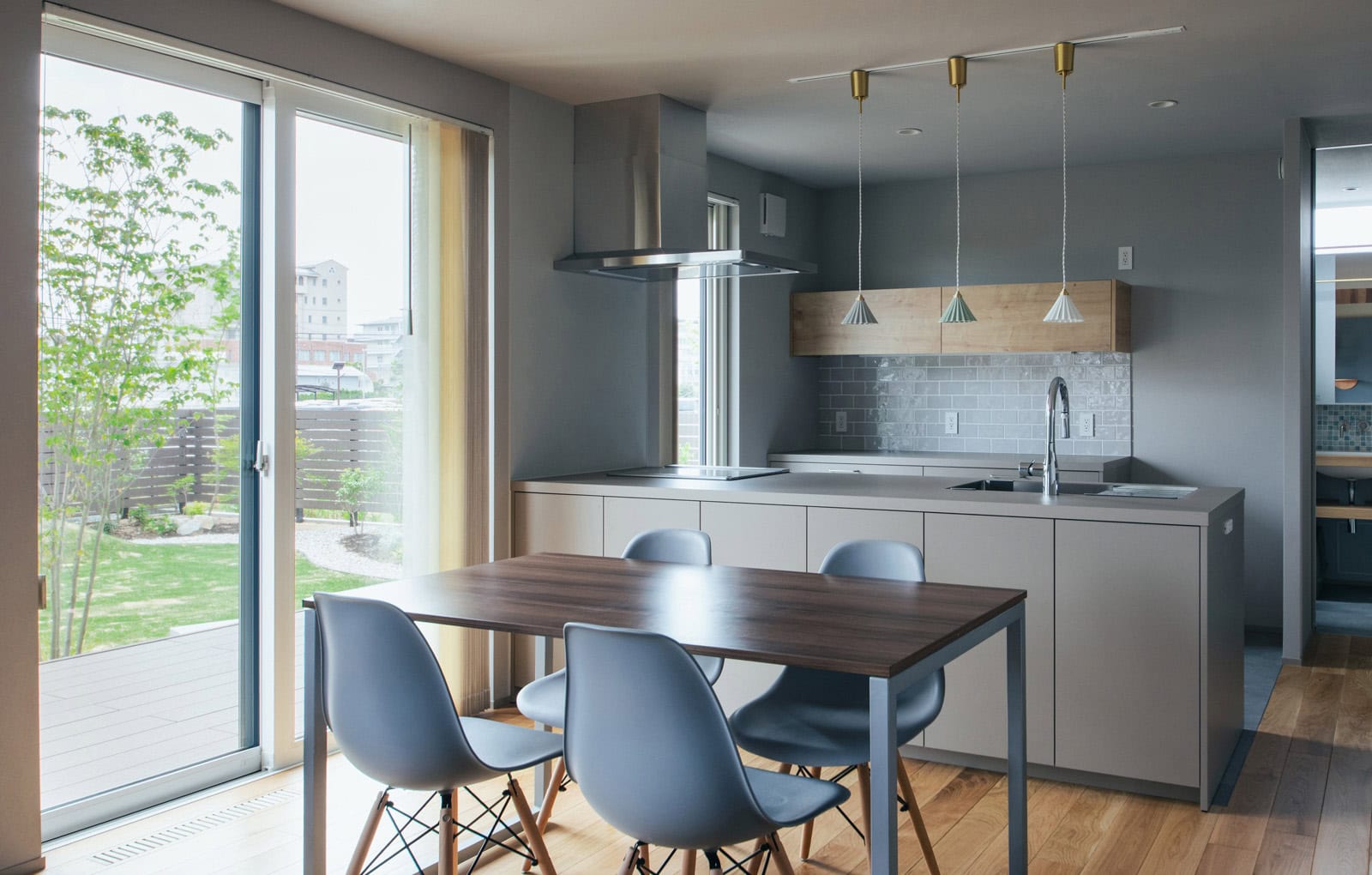 ダイニングから庭の緑を望む、キッチンとつながる空間