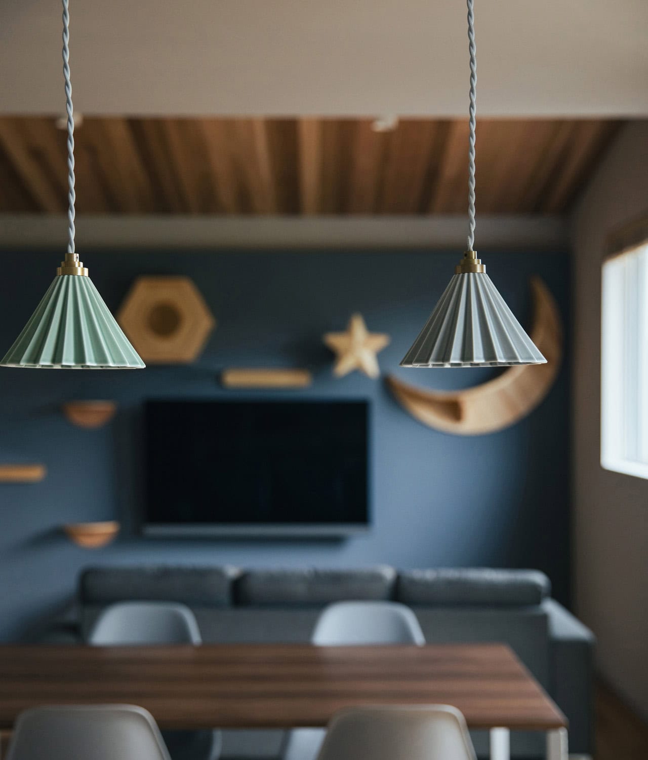 ペンダントライト越しに見る、リビングとキャットステップのある空間