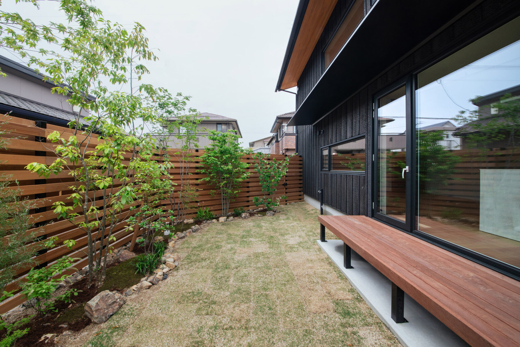 木製フェンスと植栽でプライバシーを確保した庭と縁側